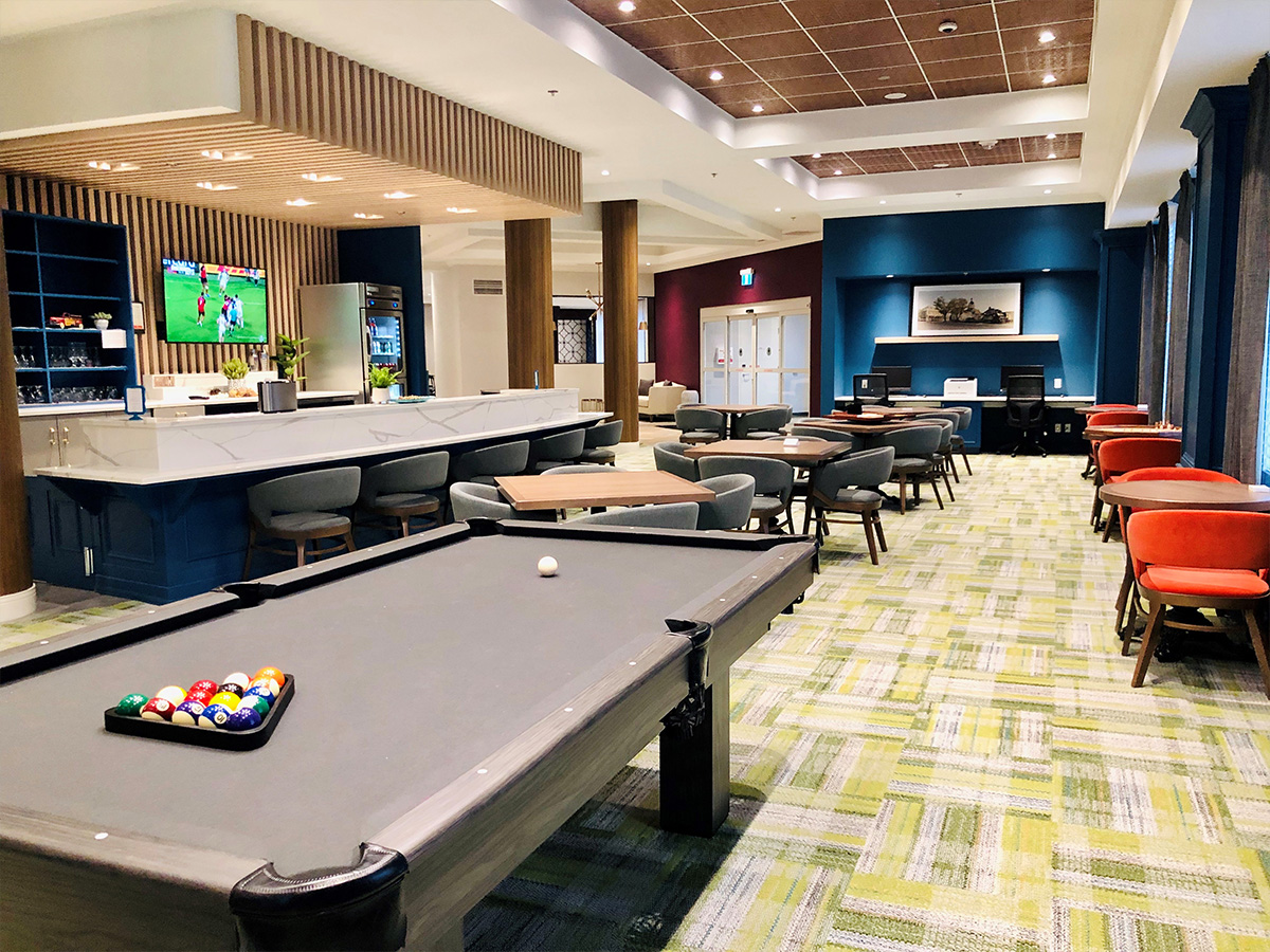 Pub-style bar and lounge with seating, pool table, and inviting interior design.